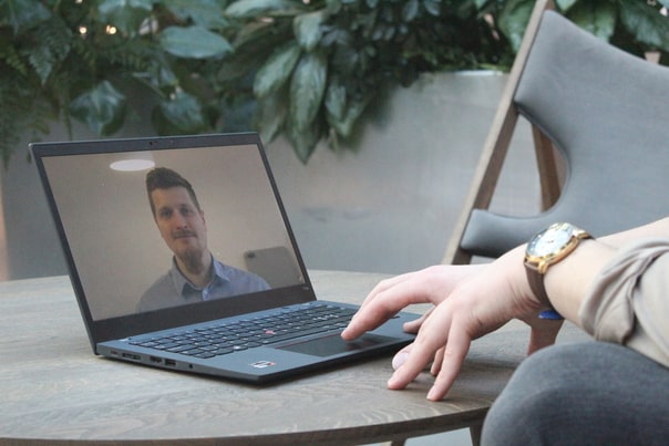 Young professional taking a therapy session via computer and talking to a therapist